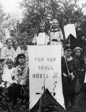 Bild från 1922 föreställande barn som håller upp en skylt där det står "För vår skull rösta JA!"